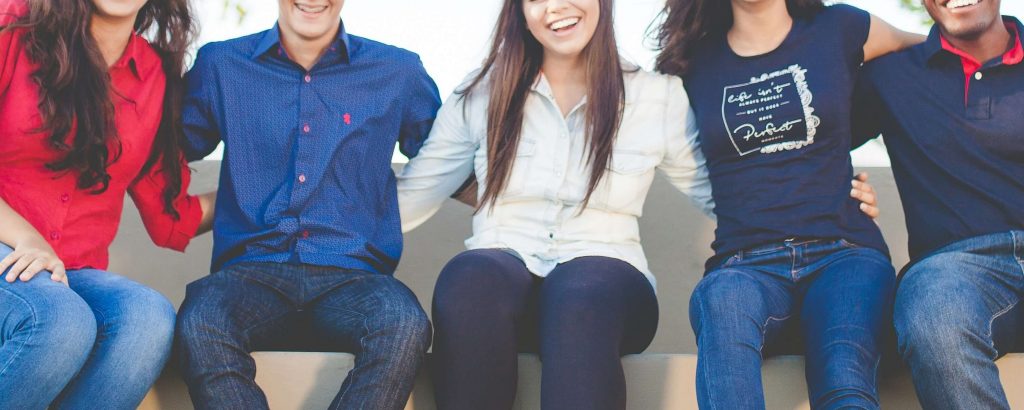 Image of a group of teens, sitting on a bench smiling with their arms around each other. Discover the ways your team can find support when it comes to their anxiety, depression, and more with the help of a skilled teen therapist in Denver, CO.