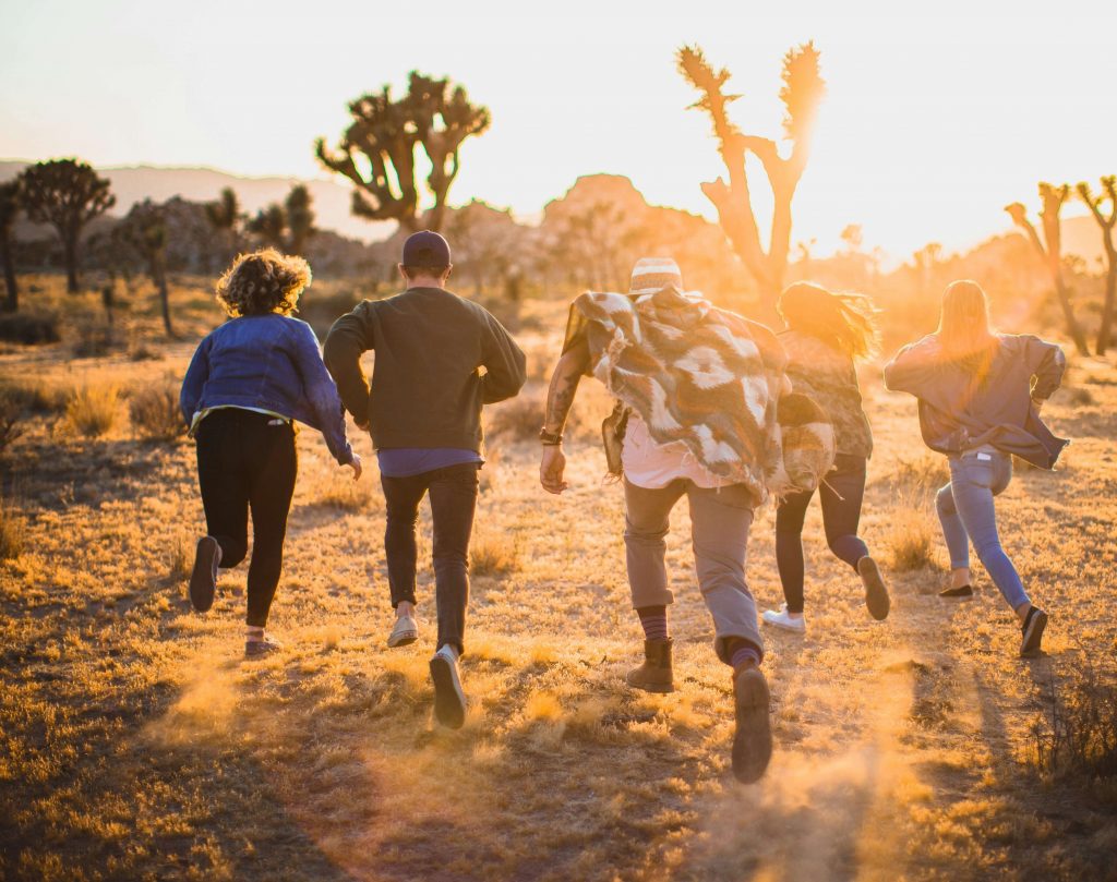 Image of teens running through the desert during sunset. Uncover how teen counseling in Littleton, CO can support your teen when dealing with anxiety, depression, trauma, and more.