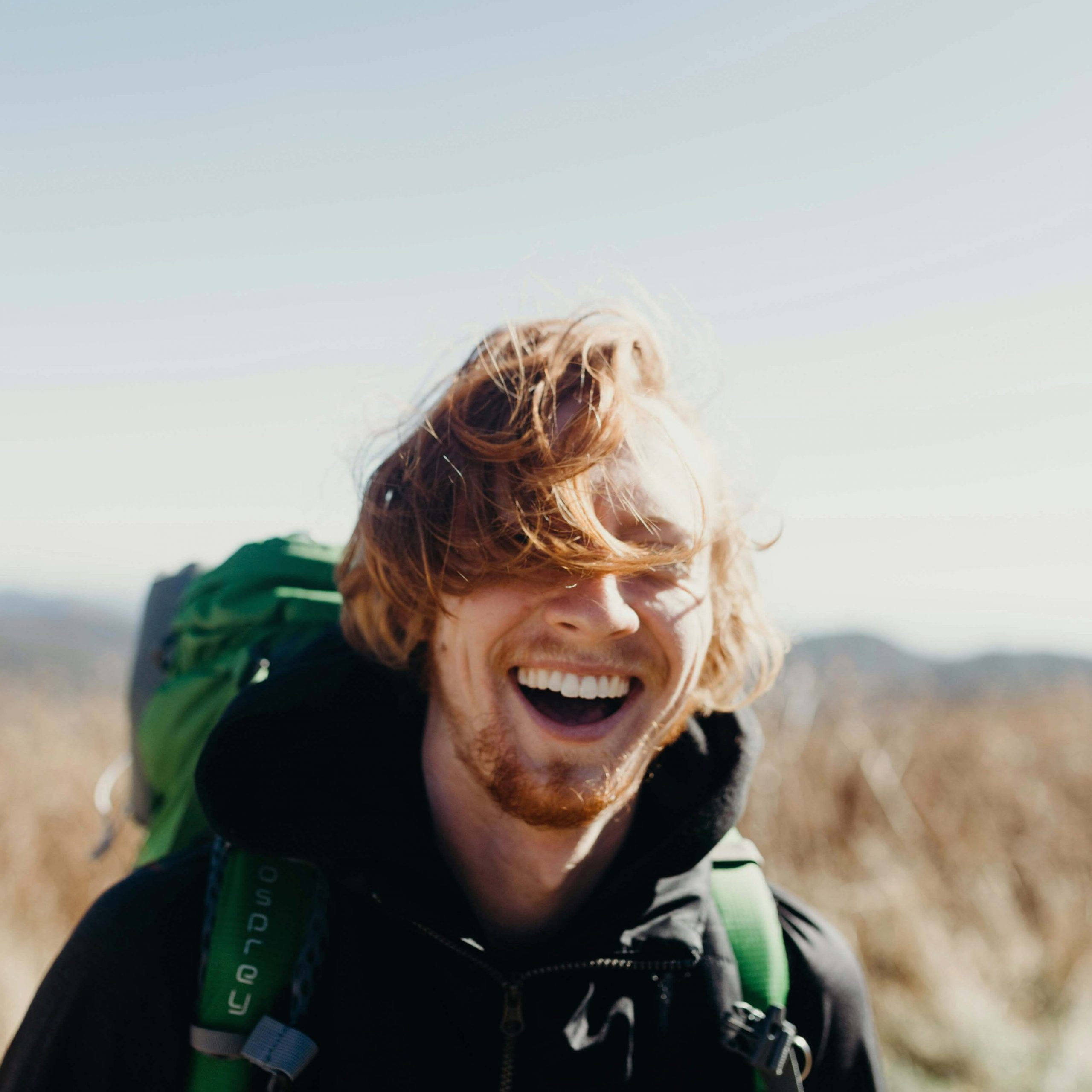 Image of a smiling man hiking on a sunny day. If you struggle with anxiety, discover how neurofeedback therapy in Denver, CO can help you manage your symptoms.