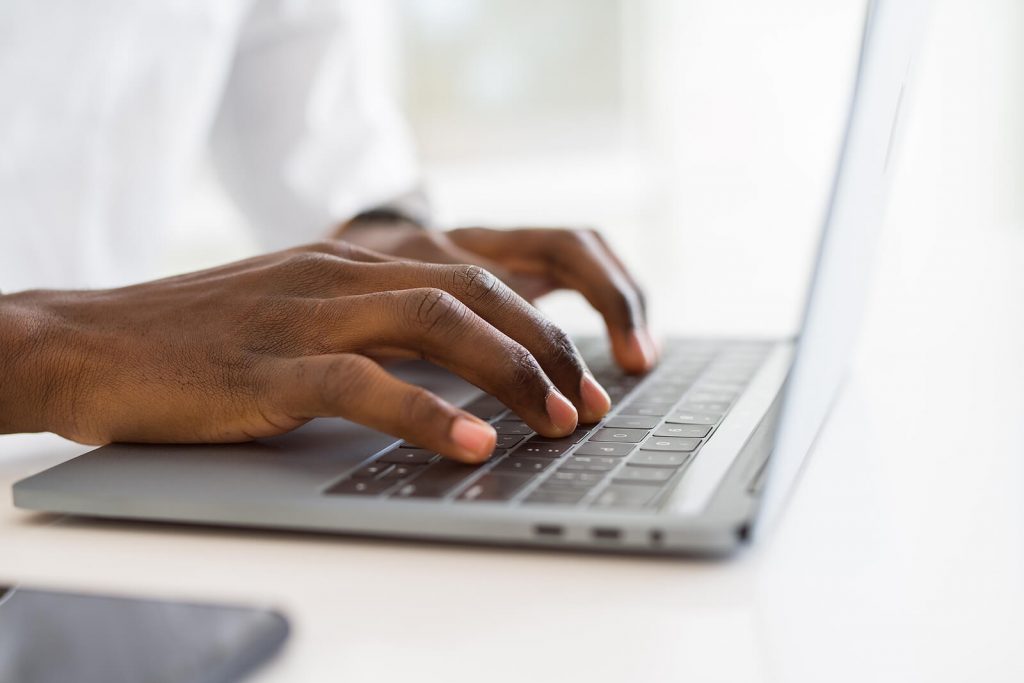 Image of hands typing on a laptop keyboard. Begin receiving helpful therapy in a convenient and accessible way with telehealth in Denver, CO.