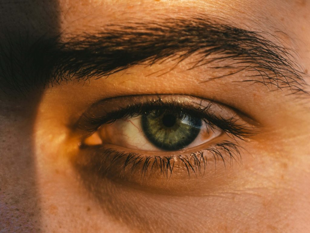 Closeup image of a young teen boy's green eye. Learn how you can heal from trauma with the help of emdr online in Denver, CO.