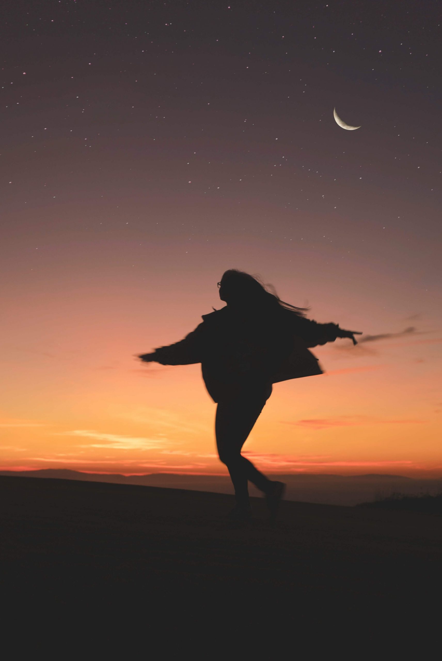 An image of a woman twirling during the sunset with the moon in the sky representing the freedom of being stress-free. Work with an anxiety therapist to manage and cope with your symptoms. Break free from the stress with anxiety therapy in Englewood, CO.