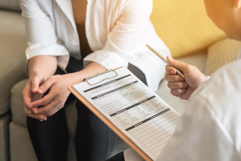 A therapist reviews intake forms with a client during an in-person or online therapy session that takes insurance, including anxiety therapy in Littleton, CO and ADHD testing options.