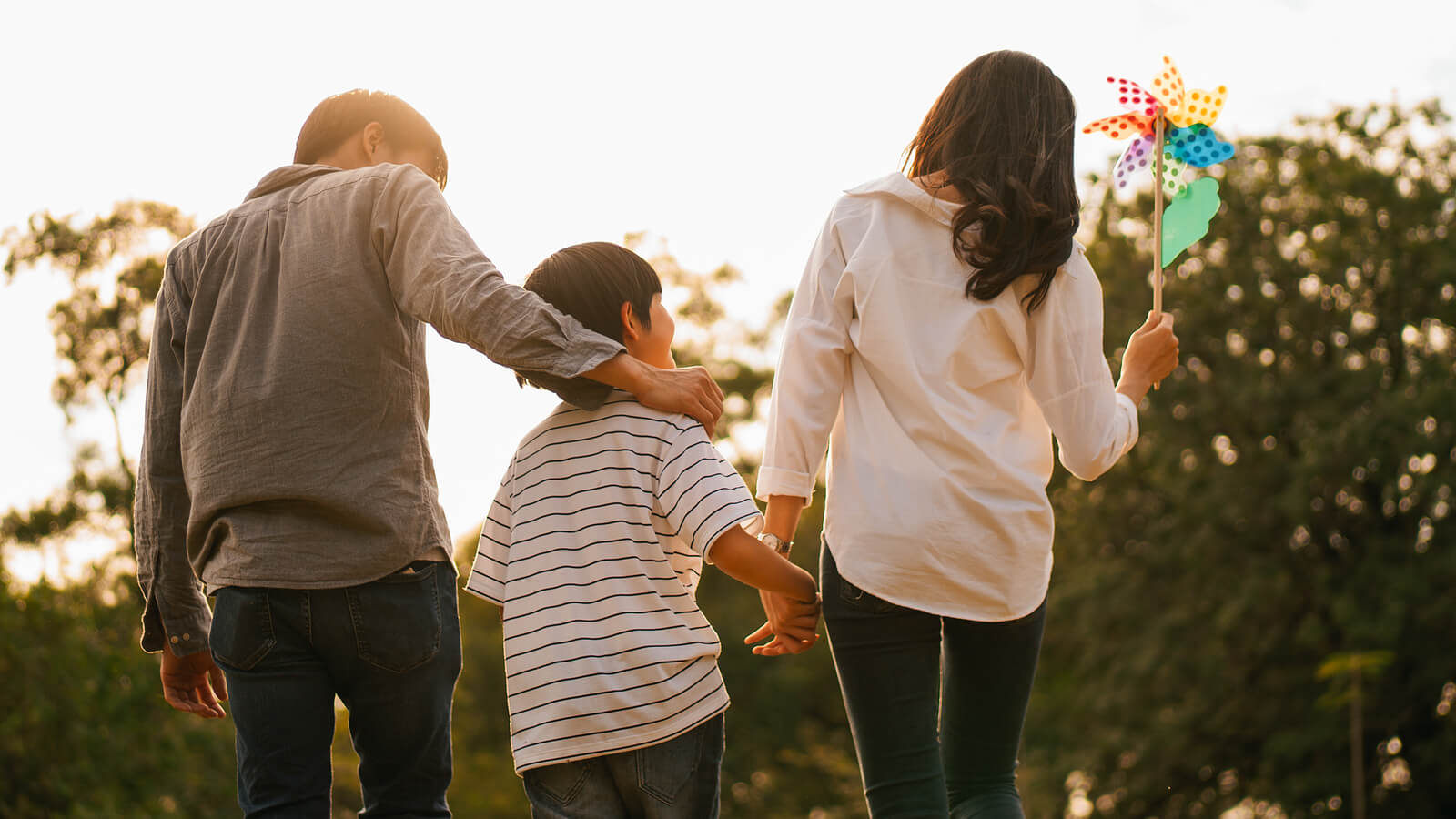 A family walks together outdoors, representing balance and healing achieved through therapy for moms, online treatment for depression in Colorado, and online therapy that takes insurance. 