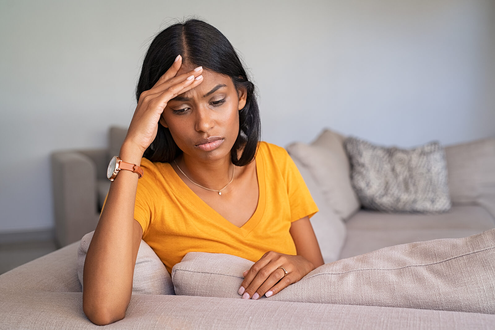 Woman resting her head on her hand on a sofa, showing burnout and masking fatigue. Works for content about supportive autism treatment for adults in colorado, care with an autism therapist in greenwood village, co, and recognizing autism in women littleton, co. 