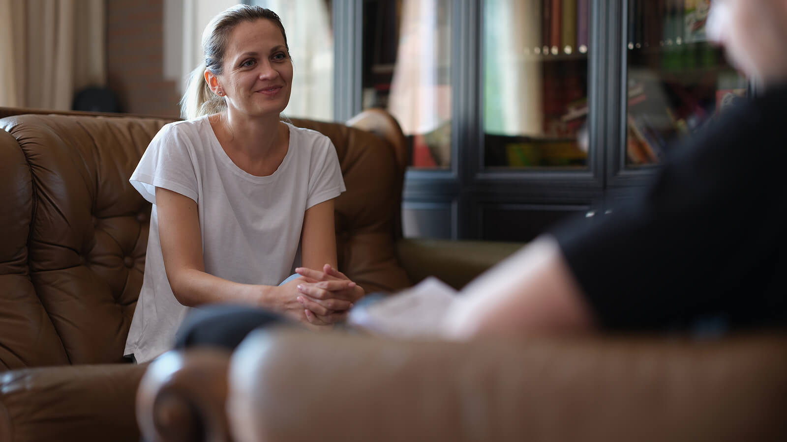 Smiling adult in a calm therapy office, conveying trust and relief during sessions. Great for highlighting an autism therapist in greenwood village, co, options for autism testing in greenwood village, co, and ongoing autism treatment for adults in colorado. 