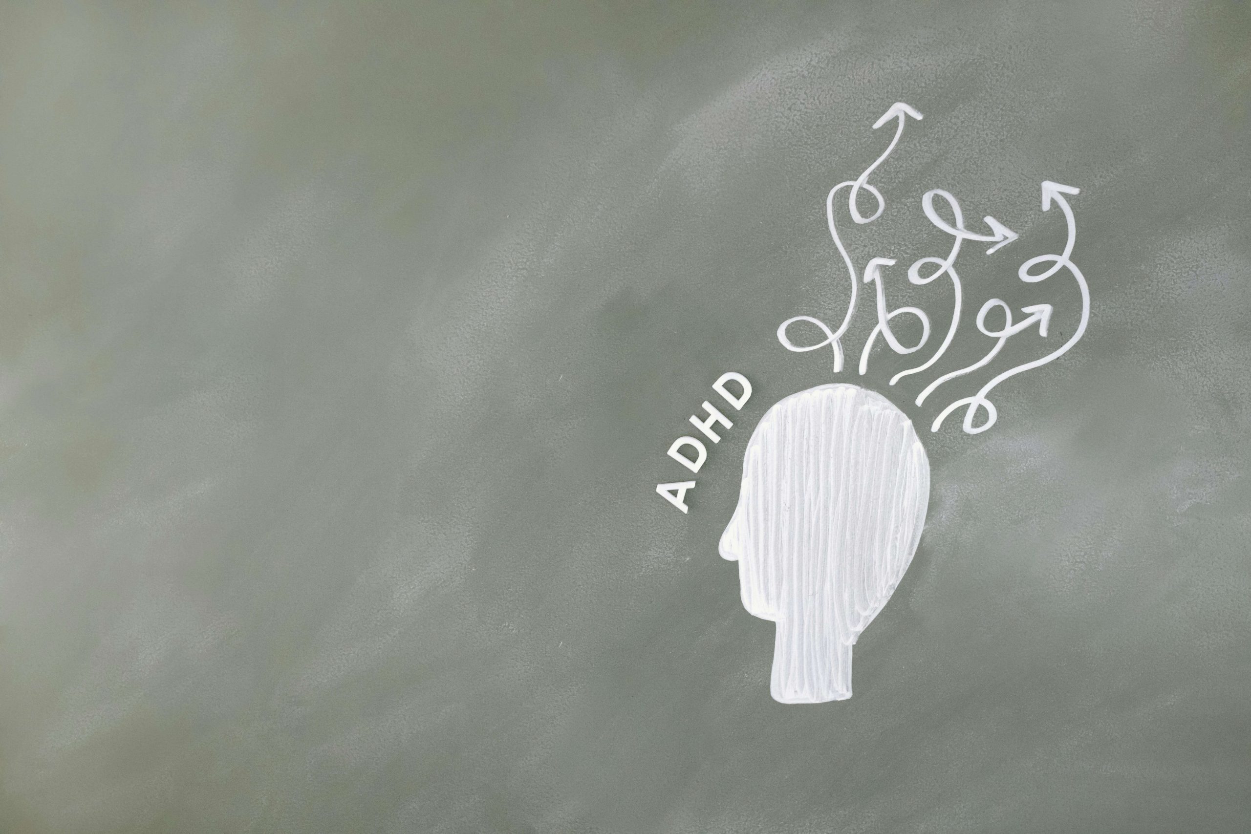 Simple chalk drawing of a head with swirling arrows, illustrating attention challenges treated with adhd therapy in Greenwood Village, CO. Helpful for those seeking adhd testing in Littleton, CO, support from an ADHD therapist for adults in Englewood, CO, and complementary neurofeedback therapy Denver. 