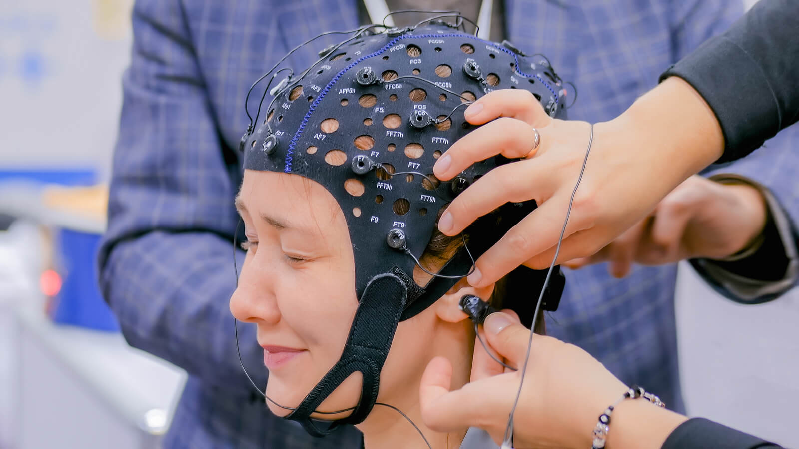 eeg helmet | neurofeedback therapist in englewood, co | neurofeedback denver | neurofeedback therapy in englewood, co | englewood,co | greenwood village, co | littleton, co Client wearing an EEG cap as a clinician adjusts sensors during a session. This shows what to expect with neurofeedback therapy in englewood, co from a neurofeedback therapist in englewood, co, especially if you’re looking for
