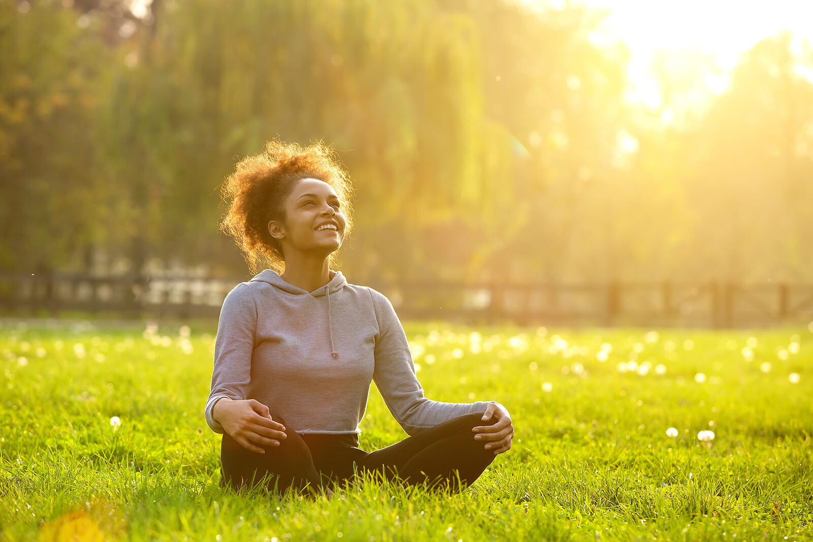 woman sitting outside | neurofeedback therapist in englewood, co | neurofeedback therapy in littleton, co | neurofeedback near me | englewood, co | littleton, co | denver, co | greenwood village, co A young woman sits cross-legged in a sunlit grassy field, smiling and looking upward with a relaxed, open expression — a powerful image of the emotional regulation, improved focus, and inner calm that neurofeedback englewood clients work toward over the course of treatment. This is what recovery and regulation can feel like: not just the absence of symptoms, but a genuine sense of ease and presence. Whether you're seeking neurofeedback therapy in Englewood, CO for ADHD, anxiety, sleep issues, or another condition, this kind of transformation is what the process is designed to support.