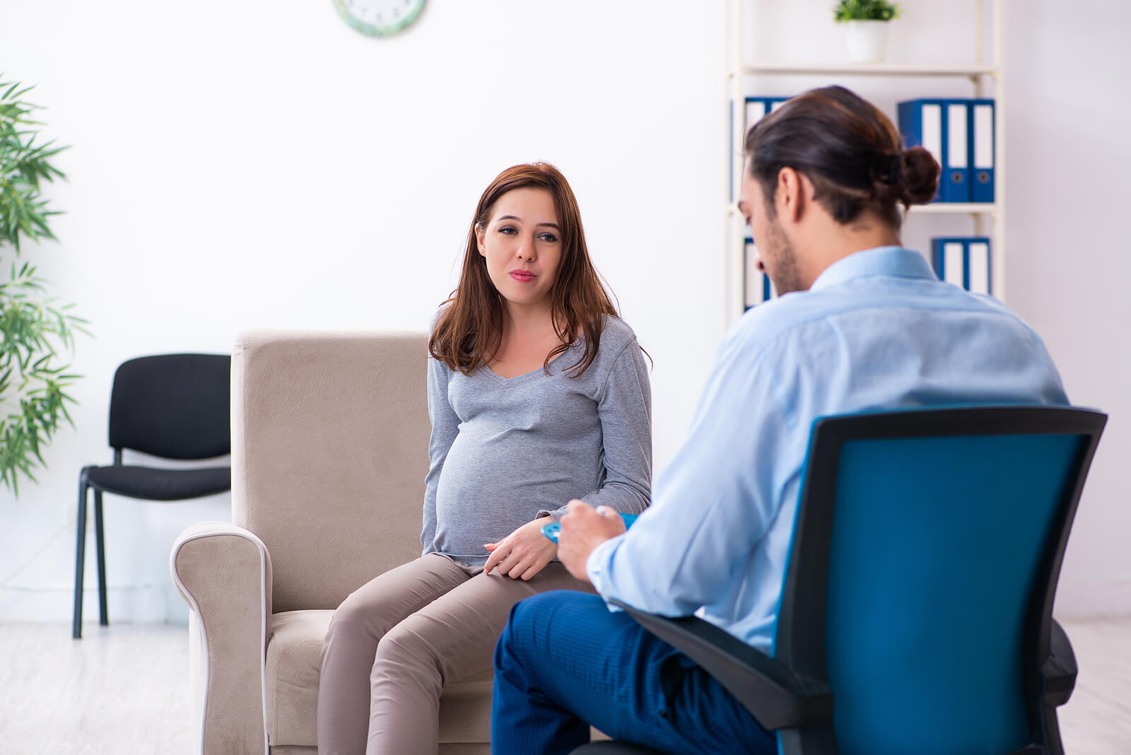 pregnant therapy session | anxiety therapist in englewood, co | postpartum therapist | postpartum anxiety therapy in greenwood village, co | englewood, co | greenwood village, co | littleton, co A pregnant woman sits across from her therapist in a calm, professional office setting, taking the important step of seeking support for her mental health during pregnancy. Working with an anxiety therapist in Englewood, CO gives expecting mothers a safe space to process their fears and develop strategies for managing antenatal anxiety. Postpartum anxiety therapy in Greenwood Village, CO and anxiety therapy in Littleton, CO are also available for mothers at every stage of their journey.